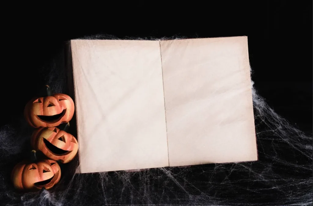 Open horror story book with Halloween pumpkins