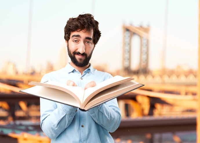 Author holding an open book while presenting a compelling story
