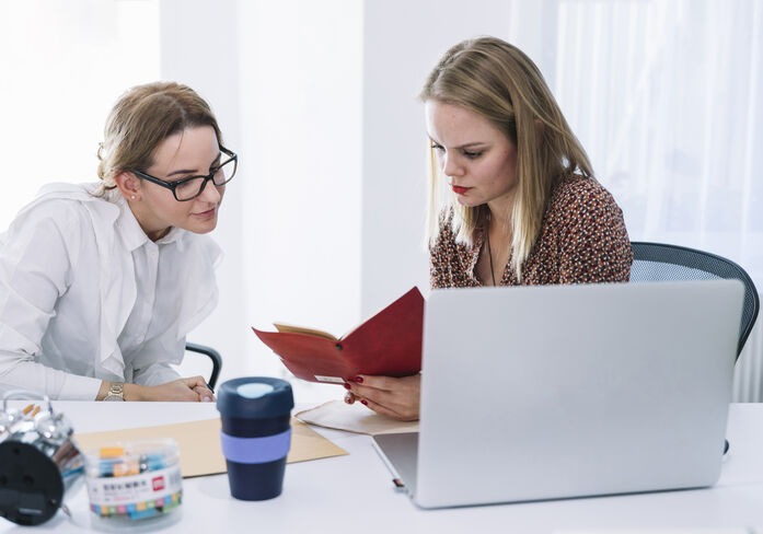 Two professionals reviewing a document together during the proofreading and editing process.