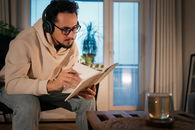 Person listening while reading an engaging book